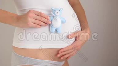 怀孕女孩<strong>抱</strong>着<strong>小熊</strong>玩具蓝色